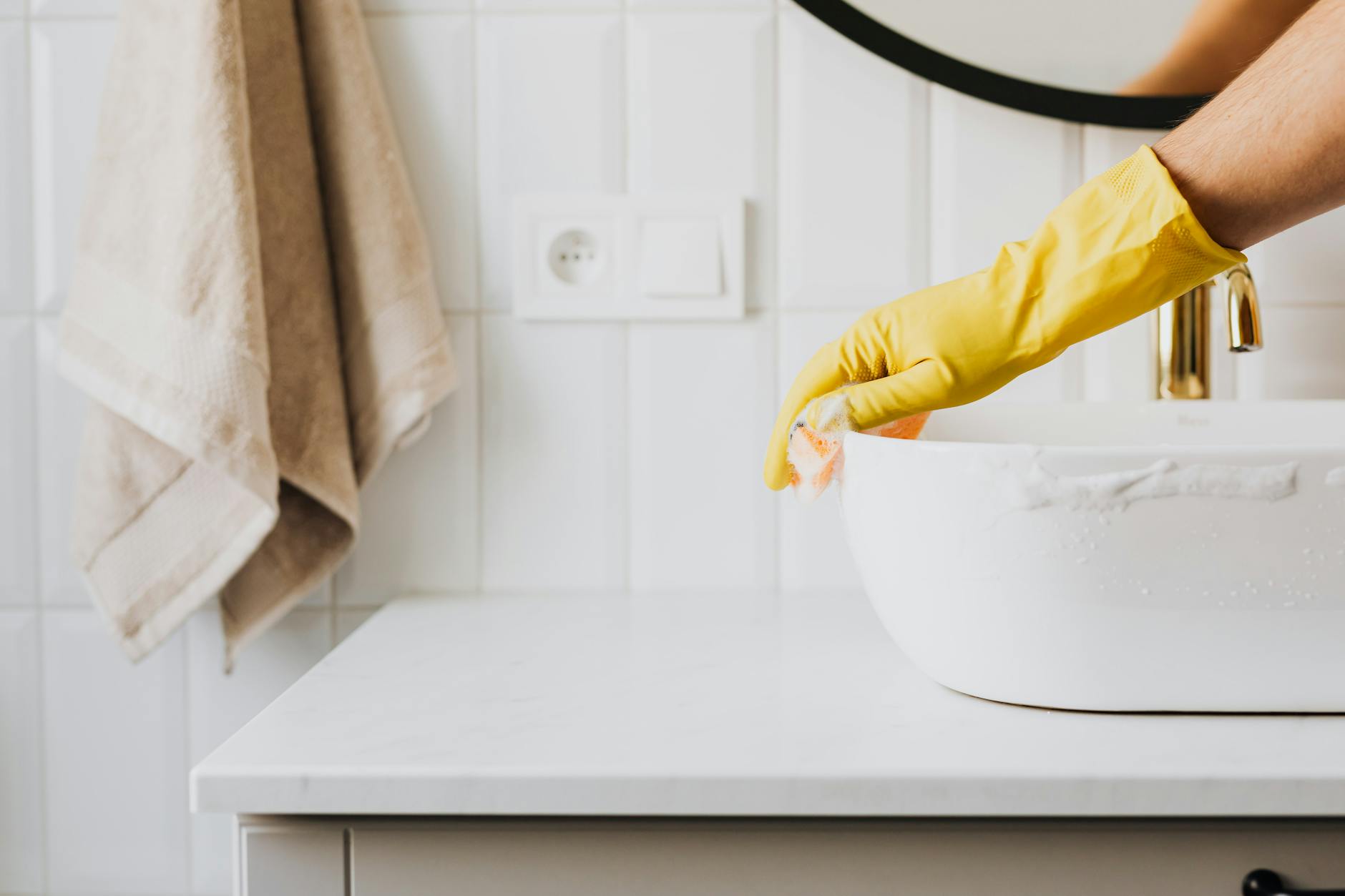 unrecognizable person washing sink in bathroom