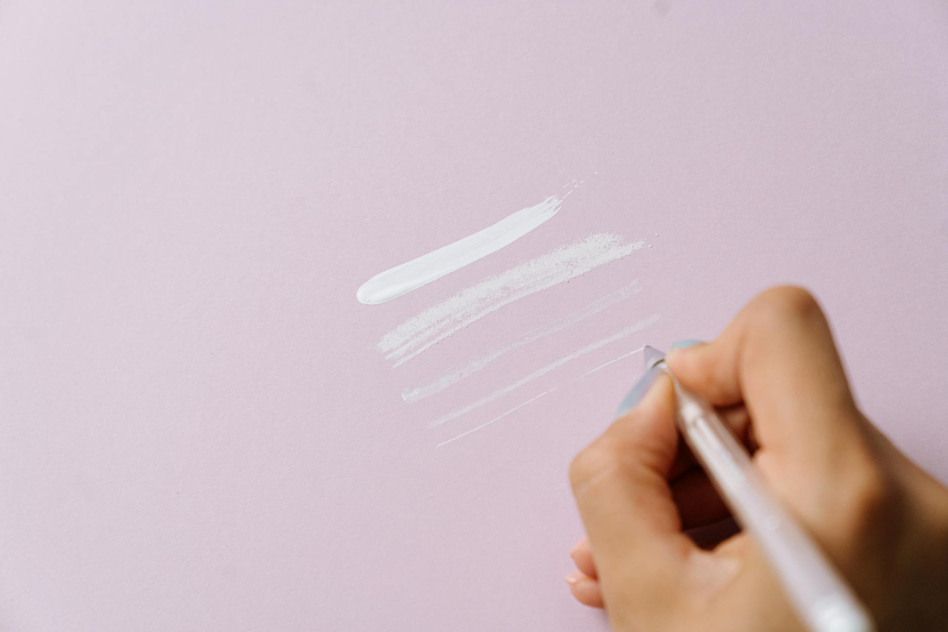 close up of a person drawing lines on light purple paper